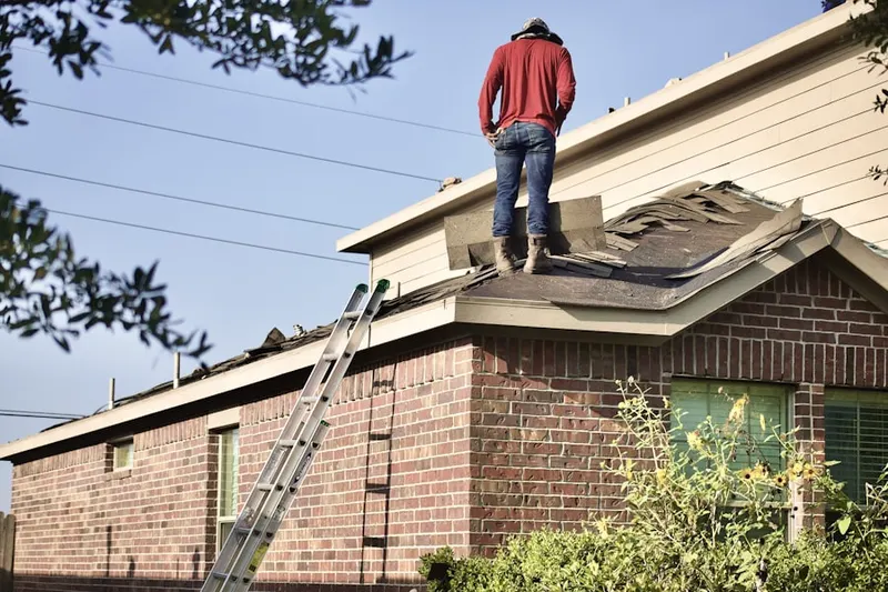 Professional roofer working on a residential roof in West End Market
